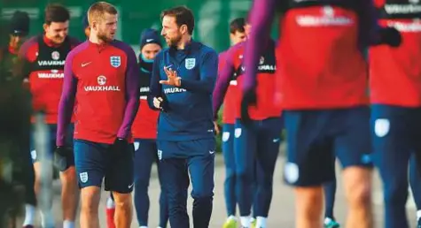  ?? AFP ?? England’s manager Gareth Southgate talks with midfielder Eric Dier as they take part in an England training session at Tottenham Hotspur FC Training Ground in Enfield yesterday.