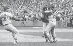  ?? ASSOCIATED PRESS FILE ?? St. Louis Cardinals pitcher Bob Gibson is hugged by catcher Tim McCarver after he pitched a three-hitter to help his team win the 1967 World Series in Game 7.