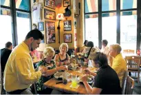  ?? MARK LENNIHAN/ASSOCIATED PRESS FILE PHOTO ?? Customers enjoy lunch in 2009 at an Applebee’s in New York. After years of working to brand itself as a modern millennial hangout, the family-friendly chain is reversing course.