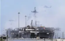  ?? Gregory Bull / Associated Press ?? Helicopter­s drop water on the burning amphibious assault ship Bonhomme Richard at Naval Base San Diego.