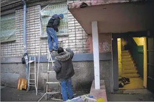  ?? RESIDENTS Bernat Armangue Associated Press ?? patch damage from a recent Russian strike in the city of Kherson, Ukraine.