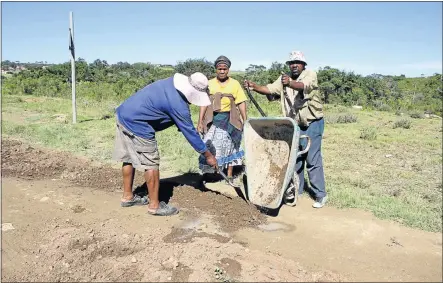  ?? Picture: BHONGO JACOB ?? HARD AT WORK: Residents from Ezikhova village in Tsholomnqa have taken it upon themselves to repair parts of badly damaged roads in their area