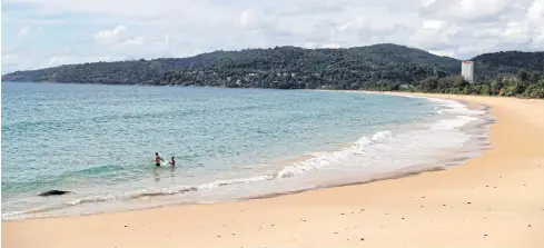 ?? REUTERS ?? People wade at an empty beach in Phuket last month.