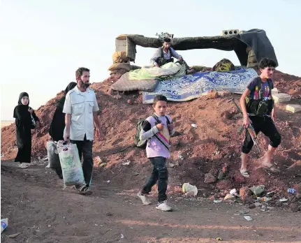  ?? Nazeer Al Khatib / AFP ?? Syrians, fleeing ISIL militants and the ongoing fighting, walk to Al Khalfatli yesterday. The village, which is considered a refuge for those displaced, is held by the Free Syrian Army, near the Syrian-Turkish border north of Aleppo.