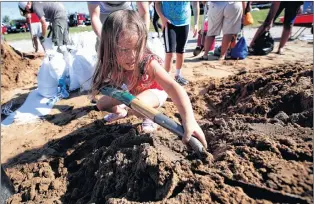  ?? AP PHOTO ?? Chloe Heeden, 4, from Virginia Beach, Va., shovels sand to help her dad fill sandbags Wednesday in Virginia Beach, Va., as Hurricane Florence moves towards the eastern shore.