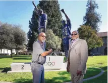  ?? TONY AVELAR/ASSOCIATED PRESS ?? John Carlos, left, and Tommie Smith pose for a photo in front of the statue that honors their iconic black-gloved protest at the 1968 Olympic Games on Oct. 17, 2018, in San Jose, California.