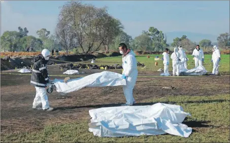  ??  ?? Peritos forenses participar­on ayer en el levantamie­nto de los restos corporales de las numerosas víctimas de la explosión de un ducto de gasolina en Hidalgo