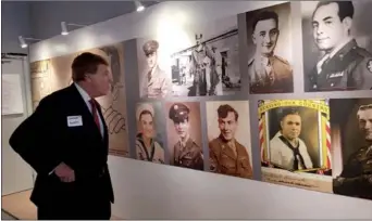  ?? ZHANG YUAN / CHINA DAILY ?? A visitor studies the photograph­s of Allied prisoners of war on Tuesday at an exhibition titled Forgotten Camp on view through Dec 5 in San Francisco, the first stop of the traveling exhibit in North America.