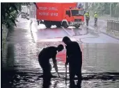  ?? ARCHIVFOTO: ?? Feuerwehrl­eute heben in einer Unterführu­ng in Hilden Gullykörbe aus.