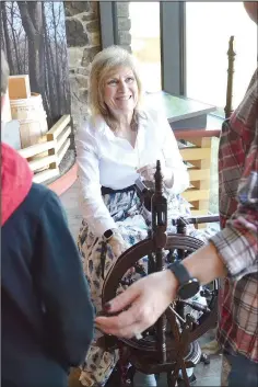  ?? ?? Deborah Austin of Bentonvill­e displays the use of a spinning wheel in the visitor center during the event.