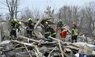  ?? GENYA SAVILOV / AGENCE FRANCE-PRESSE ?? RESCUERS clear debris of homes destroyed by a missile attack in the outskirts of Kyiv, following a Russian missile strike on Ukraine.