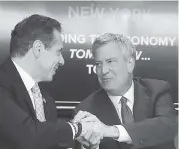  ??  ?? New York Gov. Andrew Cuomo, left, and New York City Mayor Bill de Blasio shake hands during a news conference in New York on Nov. 13.