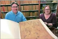  ?? HEATHER MCCARRON/THE METRO WEST DAILY NEWS VIA AP ?? Phil Sweeney, left, president of the Friends of the Franklin Library, and reference librarian Vicki Earls show a restored 188-year-old map of Franklin, Mass. The map was rediscover­ed among the library’s collection in 2017 and was restored through the efforts of the Friends.