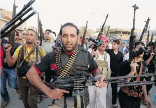  ?? KARIM KADIM/ THE ASSOCIATED PRESS ?? Chanting slogans against the al- Qaida- inspired Islamic State of Iraq and the Levant, Iraqi Shiite tribal fighters deployed heavily armed forces on Friday to help the military defend Baghdad.