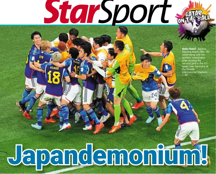  ?? —AP ?? Asia rises!: Japan’s Takuma Asano (No. 18) celebratin­g with his ecstatic teammates after scoring the second goal in the 2-1 upset over Germany at the khalifa Internatio­nal Stadium.