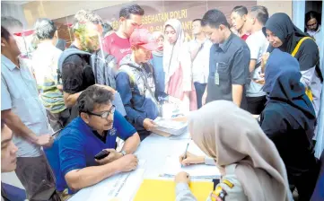  ??  ?? Family members of victims of the ill-fated Lion Air flight JT 610 submit papers and photograph­s of their lost relatives at a disaster victim identifica­tion unit at a police hospital in Jakarta.