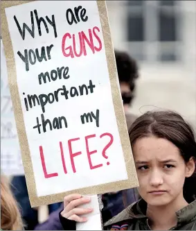  ?? BEN GARVER/THE BERKSHIRE EAGLE VIA AP ?? Maura Palden from Bard College at Simon’s Rock protests along Main Street in Great Barrington, Mass., Friday, as they take part in a national school walkout event to protest gun violence. Protests were held across the country Friday, on the 19th anniversar­y of the Columbine High School shooting.