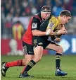  ??  ?? Crusaders prop Wyatt Crockett wraps up Hurricanes first-five Beauden Barrett during the clash in Christchur­ch.