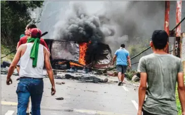  ?? GEORGE CASTELLANO­S/AFP ?? Venezuelan opposition activists set up barricades during a demonstrat­ion against President Nicolás Maduro in San Cristobal, on Monday.