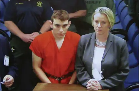  ?? SUSAN STOCKER — SOUTH FLORIDA SUN-SENTINEL VIA AP ?? A video monitor shows school shooting suspect Nikolas Cruz, left, making an appearance before Judge Kim Theresa Mollica in Broward County Court, Thursday in Fort Lauderdale, Fla. Cruz is accused of opening fire Wednesday at the school killing more than...