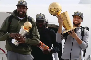  ?? Tribune News Service photo ?? From left: Golden State Warriors’ Kevin Durant, Draymond Green and Steph Curry exit a plane after it arrives at Oakland Internatio­nal airport on Saturday.