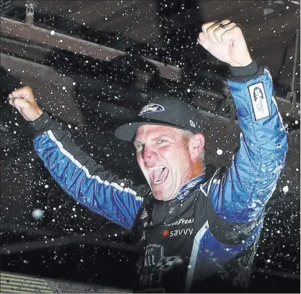  ?? Carlos Osorio ?? The Associated Press Clint Bowyer enjoys the traditiona­l postrace dousing after winning a shortened NASCAR Cup Series Firekeeper­s Casino 400 on Sunday.