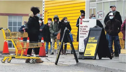  ?? CLIFFORD SKARSTEDT EXAMINER ?? Customers wait in a physically distanced lineup outside Greg’s No Frills grocery store on Wednesday. Wearing a mask or face covering is now recommende­d outdoors when you can’t physically distance more than two metres.