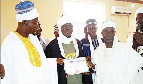  ??  ?? Director, Muslim Rights Concern (MURIC), Professor Ishaq Akintola (middle) being turbaned as ‘Lion of Scholars’ (Kinniun Adinni) by the League of Imams and Alfas Igando/ikotun Chapter, Lagos State.