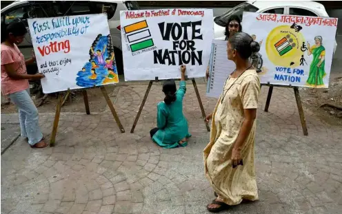  ?? AFP/VNA
Photo ?? Students in Mumbai
put the nishing touches to posters encouragin­g people to vote in India's general election,
which began yesterday.