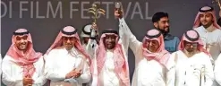  ??  ?? Saudi actor Saed Khader (center) waves his honor award for his achievemen­ts at the opening ceremony of the fourth Saudi Film Festival held in Dammam City, 400 kilometers east from Saudi capital Riyadh.