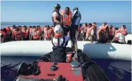  ?? AP ?? Rescuers transfer African migrants to a rescue boat during a rescue operation from the Aquarius vessel of SOS Mediterran­ee NGO and MSF (Doctors Without Borders) in the sea some 25 nautical miles (29 miles, 46 kilometres) north of the Libyan coast, on...