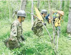  ?? (AP FOTO) ?? SEARCHING. Members of the Ground Self-Defense Force search for Yamato Tanooka in a forest at Nanae town, in Japan's northernmo­st main island of Hokkaido.