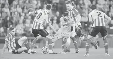  ??  ?? Barcelona’s Lionel Messi in action with Athletic Bilbao’s Ander Iturraspe and Eneko Boveda. — Reuters photo