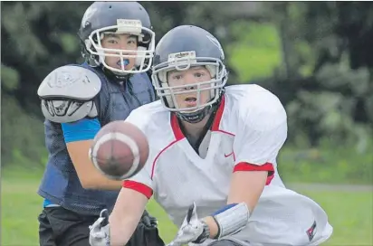  ?? JASON MALLOY/THE GUARDIAN ?? Chad Blanchard, right, prepares to catch a pass during P.E.I. Privateers practice Wednesday in Charlottet­own.