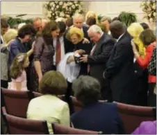 ?? THE ASSOCIATED PRESS ?? In this 2012 photo provided by a former member of the church, Word of Faith Fellowship leader Jane Whaley, center, holds a baby with others during a church ceremony in Spindale, N.C. The Associated Press has uncovered numerous instances in which Word...