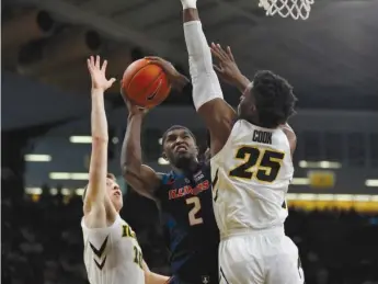  ?? MATTHEW PUTNEY/AP ?? Illinois forward Kipper Nichols puts up a shot between Iowa’s Joe Wieskamp and Tyler Cook.