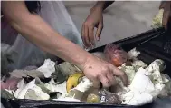  ?? AP PHOTOS ?? Persons search a garbage bag for vegetables and fruit outside a supermarke­t in downtown Caracas, Venezuela. Unemployed people picking through food tossed out by nearby shops are frequently joined by small business owners, college students and...