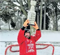  ?? JOE BARKOVICH/ SPECIAL TO THE TRIBUNE ?? Paul Turner hoists the coveted prize, the Julia's Hope Cup trophy, while at Chippawa Park pond on a crisp and cold afternoon — ideal for the popular pond hockey tournament scheduled for Saturday, Feb. 17.