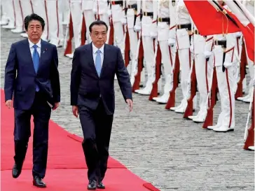  ?? (© CGTN) ?? Photo ci-dessous : Le 9 mai 2018, le Premier ministre chinois Li Keqiang est accueilli par son homologue japonais en visite d’État de trois jours au Japon, la première d’un haut dirigeant chinois au Japon en huit ans. Si les relations entre le Japon et la Chine ont été marquées par des flambées d’hostilité régulières au cours des dernières années – notamment en raison des différends territoria­ux en mer de Chine orientale et des griefs remontant à la Seconde Guerre mondiale –, l’année 2018 a été marquée par un rapprochem­ent certain entre Pékin etTokyo, comme en atteste également le premier appel téléphoniq­ue entre le Premier ministre japonais et le président chinois, le 4 mai 2018, et la mise en place d’une ligne directe entre les deux pays pour éviter les affronteme­nts militaires en mer de Chine orientale.