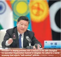 ?? LI XUEREN / XINHUA ?? President Xi Jinping presides over a session of the 18th Shanghai Co-operation Organisati­on Summit in Qingdao. He called for a world economy that rejects "self-centred" policies.