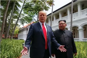  ?? Associated Press ?? ■ President Donald Trump walks Tuesday with North Korean leader Kim Jong Un on Sentosa Island in Singapore.