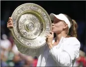  ?? GERALD HERBERT — THE ASSOCIATED PRESS ?? Kazakhstan's Elena Rybakina kisses the trophy as she celebrates winning the women's title at Wimbledon.