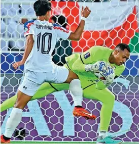  ?? ?? Oman goalkeeper Ibrahim Al Mukhaini makes a save to deny Thailand’s Suphanat Mueanta