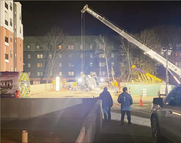  ?? Trevor Ballantyne/Hearst Connecticu­t Media ?? A crane was used to lift a truck that fell through a parking garage on Crosby Street in Danbury on Monday. The driver, who was outside the vehicle when the incident occurred, was injured.