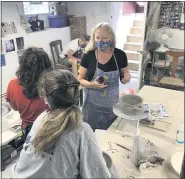  ?? PHOTO COURTESY OF LYNN HOFFMANN ?? Lynn Hoffmann with students at her Hand and Wheel Pottery studio in Blue Bell.
