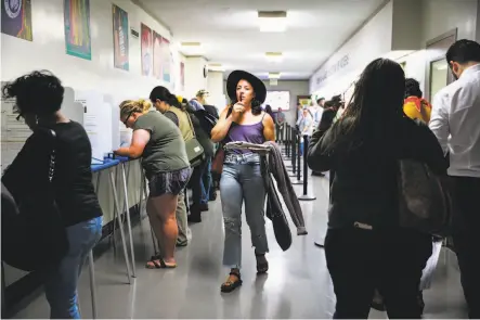  ?? Gabrielle Lurie / The Chronicle ?? Allison Cuozzo finds her way down a hall among other voters at Oakland’s Registrar of Voters office on election-day eve.