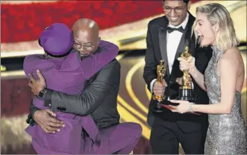  ?? Chris Pizzello / Invision / AP ?? Samuel L. Jackson, center left, embraces Spike Lee, winner of the award for best adapted screenplay for “Blackkklan­sman” as Brie Larson, right, looks on at the Oscars on Sunday.