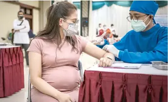  ?? GETTY IMAGES ?? A pregnant woman gets a vaccine against COVID-19 earlier this month in Yogyakarta, Indonesia.