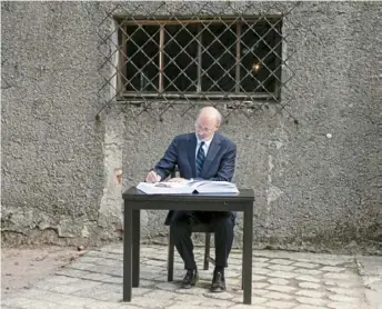  ?? Amanda Berg/Office of Gov. Tom Wolf ?? Gov. Tom Wolf signs the names of the Tree of Life shooting victims in the guest book at Auschwitz on Sept. 14.