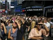  ?? ASSOCIATED PRESS ?? A crowd reacts as clouds move to reveal a partial solar eclipse Monday in New York.
